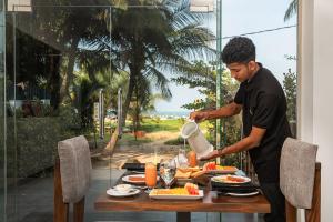 a man preparing food on a table at Beverly Beach Hotel & Transit in Negombo