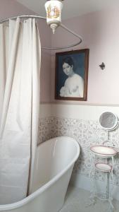 a bath tub in a bathroom with a picture of a woman at B&b Miele&mare in Melendugno