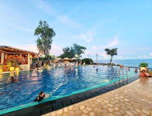 a swimming pool with people in the water at Mactan Newtown Ocean View 360 Degree in Mactan