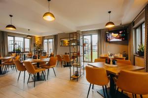 restauracja z drewnianymi stołami i krzesłami oraz oknami w obiekcie Osada Śnieżka koło Karpacza w mieście Karpacz