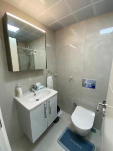 a bathroom with a sink and a toilet and a mirror at Marina Guest House in Çeşme +4 photos