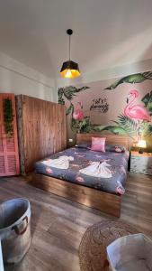 a bedroom with a large bed with flamingos on the wall at Byout Beirut’s M2 in Beirut