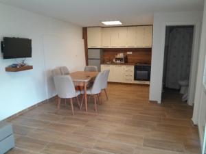 a kitchen and dining room with a table and chairs at Apartman Riste in Trpejca +15 photos
