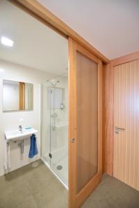 a bathroom with a shower and a glass door at Casa da Baía - Guest House in Horta