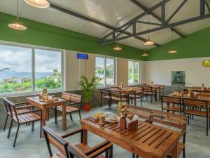 a restaurant with wooden tables and chairs and windows at The Hosteller Kodaikanal in Kodaikānāl