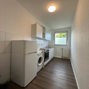 a kitchen with a white refrigerator and a washer at WDI - Workers Apartments in Herten