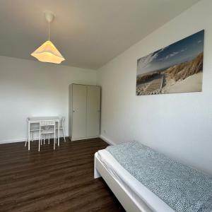 a bedroom with a bed and a table and a cabinet at WDI - Workers Apartments in Herten
