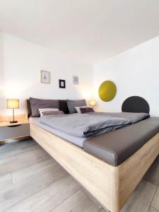a bed with a wooden frame in a bedroom at Flair Apartments 'FACHWERK & FLAIR' - Altstadt-Apartment 78 qm für Urlaub oder Geschäftsreise, Innenstadtlage, ruhig, modern, 900 m Bahnhof, 24 Std Check-in, WLAN, Streaming, Küche, Regendusche, 2 x Doppelbett, direkt am neuen Markt in der Altstadt in Herford