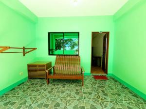 a living room with a bench and a flat screen tv at Resort Manuela Panglao in Panglao Island