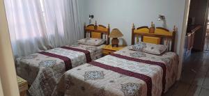 a bedroom with two beds and a lamp at Olive rest in Wesselsbron