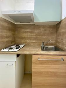 a kitchen with a sink and a stove at Échappée Bohème & Lumière in La Grande-Motte