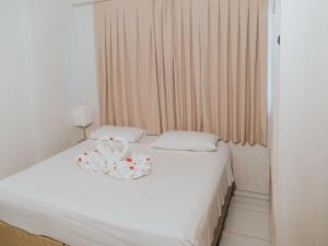 a bedroom with a white bed with a basket on it at Apto 207 - Golden Dolphin SUPREME in Caldas Novas