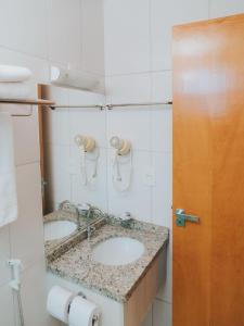 a bathroom with two sinks and a mirror at Apto 207 - Golden Dolphin SUPREME in Caldas Novas