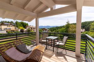 a balcony with two benches and a table and a view at Fai le Coccole in Fai della Paganella