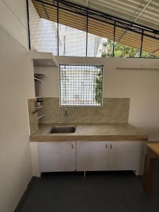 a kitchen with a sink and a large window at Bindas in Trivandrum