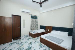 a hotel room with two beds and a cabinet at Hotel Shri Balaji Dham, Family Room Near Mathura Railway Station in Mathura