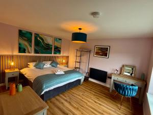 a bedroom with a bed and a desk and a television at Luxury One Bedroom Cabin - Heatherbank Cabin in Portree