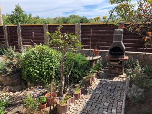 ein Garten mit Pflanzen und ein Ofen in einem Zaun in der Unterkunft Casa EVY in Eforie Nord