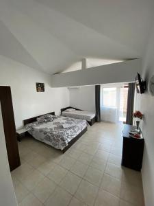 a bedroom with a bed in a white room at Casa EVY in Eforie Nord