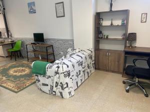 a living room with a couch and a desk at Green apartment in Tbilisi City