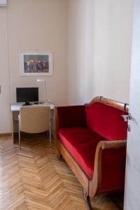a living room with a red couch and a desk at CASA MIRELLA in Casale Monferrato