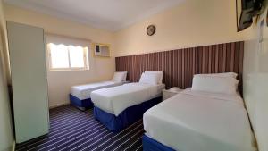 a hotel room with two beds and a window at فندق مهوى الفؤاد 1 ذاخر توصيل مجاني للحرم Mahwa Alfoad 1 Hotel free bus to Haram in Mecca