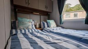 two beds in a room with a window at The Ocean Nook in New Quay +33 photos