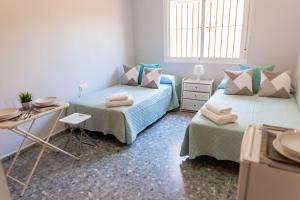 a bedroom with two beds and a table and a desk at La Casa Grande de Casapalma in Cártama +91 photos
