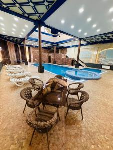 a swimming pool with chairs and a table and a tablektop at Garden Boutique Hotel in Bukhara