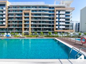 una piscina frente a un gran edificio de apartamentos en Serenity Studio with Balcony at Azizi Riviera, en Dubái