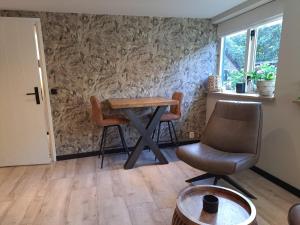 a room with a table and two chairs and a window at B&B Buitengewoon in Fochteloo