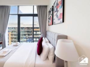 Un dormitorio con una cama blanca y una ventana grande. en Modern Comfort Studio Relax & Unwind in Style, en Dubái 21 fotos más
