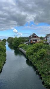 ein Fluss mit Gebäuden am Ufer in der Unterkunft Gîte Le Guet du Roy in Boismont