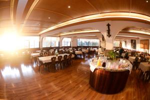 a restaurant with tables and chairs in a large room at Hotel 13 Linden in Treze Tílias +32 photos