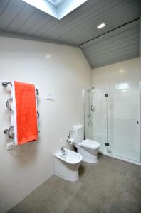 a bathroom with a toilet and a shower and a sink at Casa da Baía - Guest House in Horta