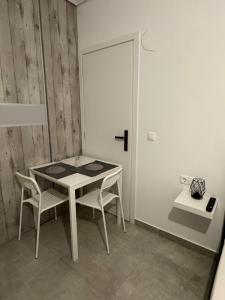 a dining room with a table and two chairs at GuccisCozyStudio in Artemida