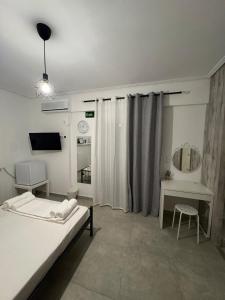 a bedroom with a bed and a table and a mirror at GuccisCozyStudio in Artemida