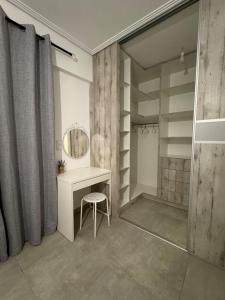 a bathroom with a vanity and a mirror and a stool at GuccisCozyStudio in Artemida