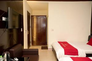 a bedroom with a bed and a television and a door at CHIEN CONG Hotel in Ha Long