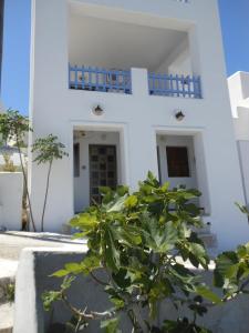 a white house with a tree in front of it at Gyrouli Studios in Astypalaia
