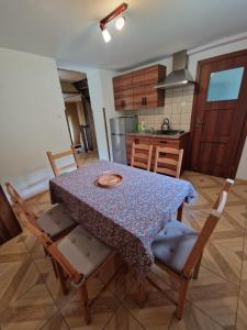 a table and chairs in a kitchen with a table and a kitchen at Bieszczady Domek u Pączka in Polańczyk