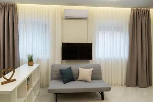 a living room with a couch and a tv at Studio Lumo in Nea Moudania
