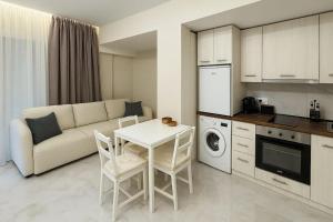 a living room with a couch and a table and a kitchen at Studio Lumo in Nea Moudania