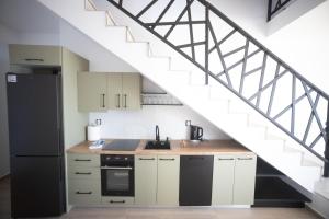 a kitchen with white cabinets and a staircase at Villa Skalia Lefkada in Athani