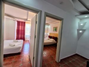 a small room with two beds and a mirror at Apartments Yll in Ulcinj