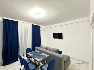 a living room with a couch and a table and chairs at MatyMar Blue in Eforie Nord