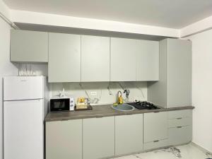 a kitchen with white cabinets and a white refrigerator at MatyMar Blue in Eforie Nord