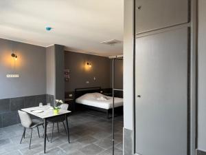 una camera d'albergo con letto e tavolo e una camera di Logements des choraux a Tournai