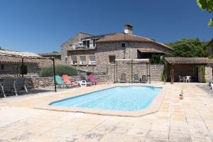 a swimming pool in front of a stone house at Micocoulier de la Maréchale in Orgnac-lʼAven