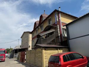 キシナウにあるHome Boutique Hotelの建物前に停車する赤い車